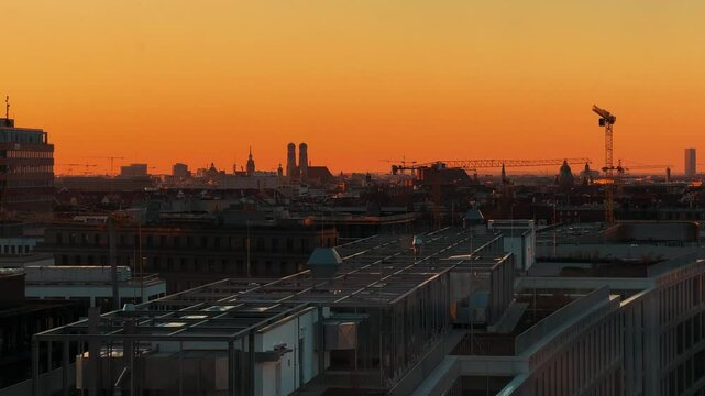 Time-lapse over Werksviertel-Mitte by sunset. Munich Bavaria Frauenkirche skyline in the distance.