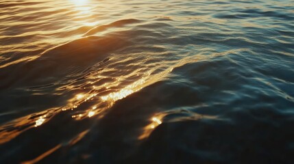Golden sunset reflecting on rippled water surface.