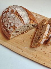 freshly cut artisanal sourdough bread showing crumb and texture on a rustic wooden surface on white table