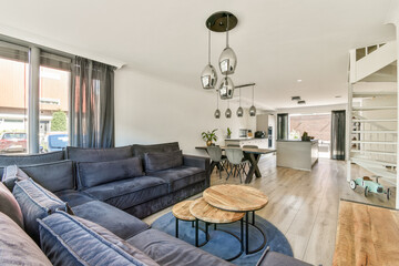 A stylish modern living room featuring a cozy sofa, elegant furniture, and a bright, open atmosphere. Ideal for relaxation and social gatherings.