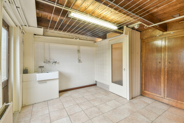 A bright and spacious interior featuring clean lines and a minimalist design. The room includes a utility sink and ample floor space, perfect for various uses.