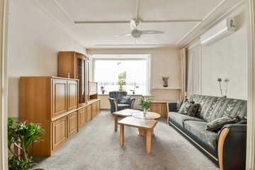 A warm and inviting living room featuring wooden furniture, comfortable seating, and decorative plants, creating a serene atmosphere for relaxation.