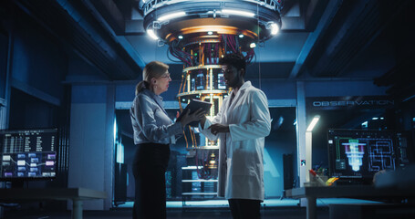 In an Advanced Science Lab, Diverse Engineers Discussing a Quantum Computer Project, Analyzing Data on a Computers. Team of Female and Male Specialists Working to Develop a Quantum Processor