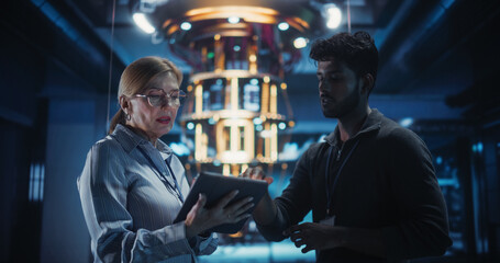 In an Advanced Science Lab, Diverse Engineers Discussing a Quantum Computer Project, Analyzing Data on a Computers. Team of Female and Male Specialists Working to Develop a Quantum Processor