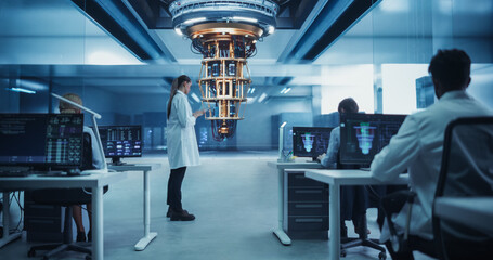 Female Scientist Working on Quantum Computer Hardware, Using Tablet Computer to Access Technical...