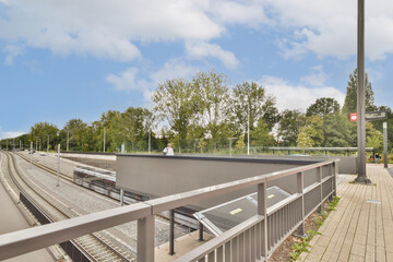 Fototapeta premium A contemporary train station featuring sleek architecture surrounded by lush trees, creating a blend of nature and urban design.