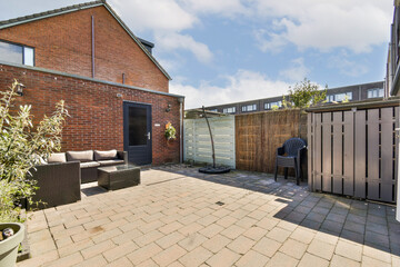 Obraz premium A stylish patio area showcasing contemporary furniture, surrounded by greenery and sleek fencing, perfect for relaxation and outdoor gatherings.