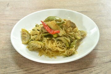 stir fried spicy mixed glass noodles with vegetables and pork belly in Curry powder Thai northern style on plate