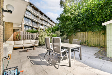 A stylish outdoor patio featuring contemporary furniture set amidst greenery and a serene atmosphere, perfect for relaxation and gatherings.