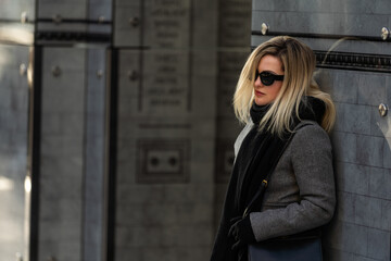 Beautiful girl in a ccoat and scarf and black glasses