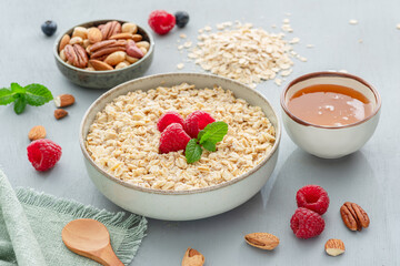 Bowl of porridge or oatmeal with fruits, nuts and honey. Breakfast cooking.