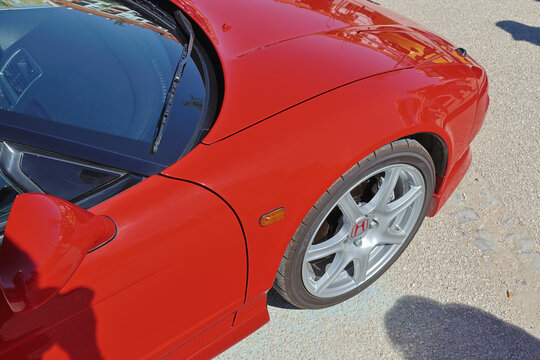 Close up of a vibrant red honda nsx, highlighting its sporty design and iconic features