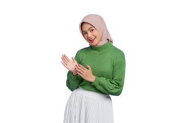 Beautiful smiling Asian woman in green sweater clapping in hands, looking at camera isolated on...