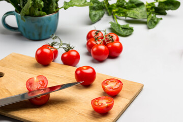 Knife and sliced red pepper. Tomatoes and spinach leaves on the table