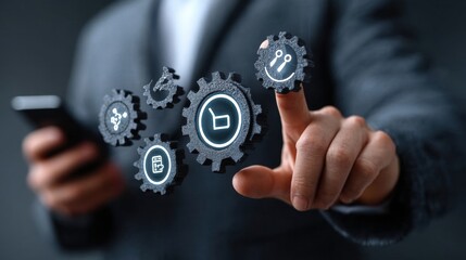 Businessman holding a smartphone and touching a gears icon with a digital hologram of icons on a virtual screen. This represents a technology business concept for information system or marketing plan
