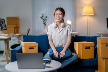 A woman is sitting on a couch with a laptop on a table in front of her