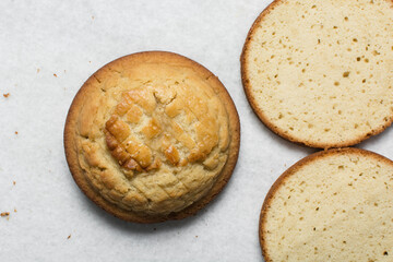 Overhead view of vanilla cake layers on a white countertop, top view of vanilla cake slices about to be assembled, process of making layered cake
