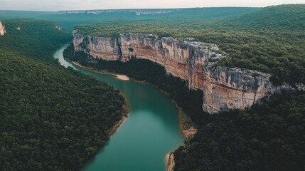 Obraz premium Emerald green river winding through limestone cliffs and lush jungle vegetation