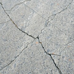 Obraz premium Close-up of a cracked concrete floor, highlighting various fissures and irregularities in the surface.