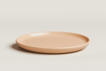 A single, empty, pale pinkish-beige ceramic plate with a matte finish sits on a neutral, off-white studio background.
