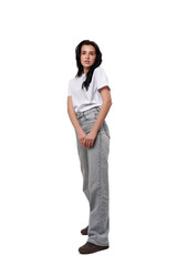 Fototapeta premium Confident young woman posing in casual attire against a plain background during a studio session