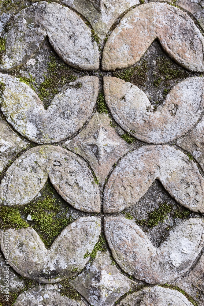 Poster Stone carving showing repeating pattern with moss growing between stones