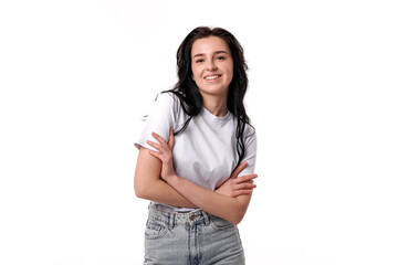 Young woman smiling confidently in casual outfit with arms crossed against a white background in a...