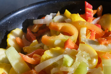 Fresh raw fried vegetables sprinkled with coarse salt in a frying pan, close up. Shallow depth...