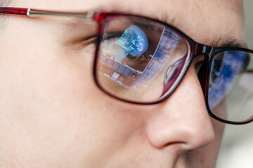 The doctor is reading the MRI scans. The glasses reflect the results. The concept of modern...