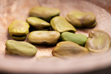 Dried Vicia faba or broad beans in wooden bowl close up