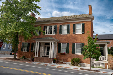 traditional American brick house in colonial style. Two floors, veranda.