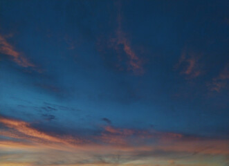 Stunning twilight sky, painted with soft peach and rose hues against a deep blue canvas. Silhouetted trees at the bottom add a touch of nature. Ideal for travel, nature, or serenitythemed projects.