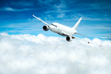 Obraz premium Airplane in the sky, white commercial flying airplane in the flight over the clouds, flying airplane closeup
