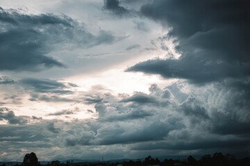 Dramatic overcast sky with gray clouds forming moody and tranquil backdrop before rain, capturing the serene yet stormy atmosphere in the cloudy weather of the rainy season. Moody and peaceful scene.M