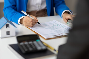 Real estate agents negotiate for businessman to legally sign home purchase agreements contract ,...