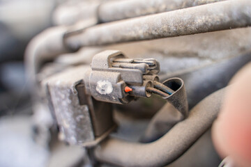 Colored wires connected to a sensor chip in a car, close-up