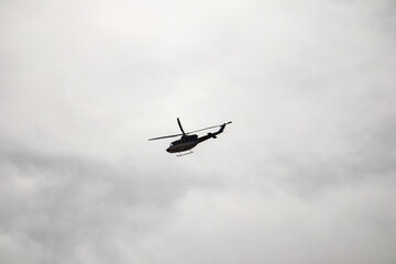 a helicopter flying in a cloudy sky.