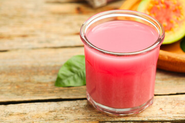 Refreshing guava juice and fresh fruits on wooden table, closeup. Space for text