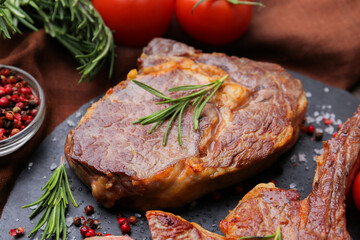 Pieces of delicious beef meat and spices on table, closeup