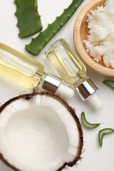 Hair treatment. Cosmetic products, coconut, butter shavings and aloe leaves on white background, flat lay