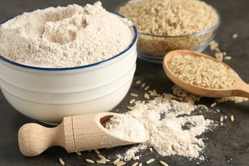 Brown rice and flour on grey table, closeup