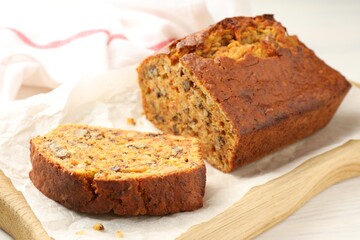 Cut homemade carrot cake with nuts on table, closeup