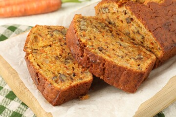 Cut homemade carrot cake with nuts on table, closeup