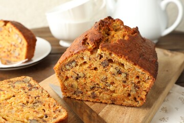 Cut homemade carrot cake with nuts and knife on table, closeup