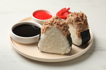 Tasty onigiri (Japanese rice balls) with tuna served on white marble table, closeup