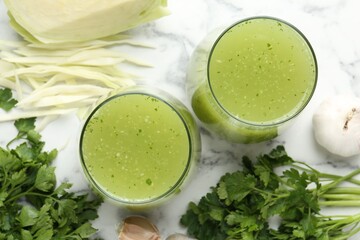 Healthy parsley smoothie, garlic, cabbage and leaves on white marble table, flat lay