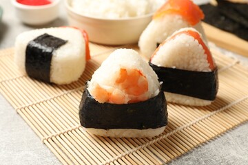 Tasty onigiri (Japanese rice balls) served on light table, closeup