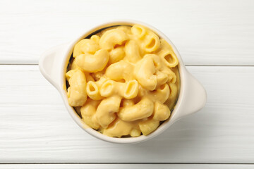 Delicious macaroni and cheese on white wooden table, top view