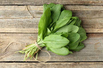 Bunch of fresh green sorrel leaves on wooden table, top view