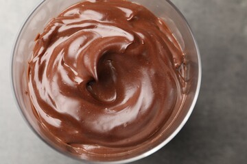 Tasty chocolate pudding on grey table, top view